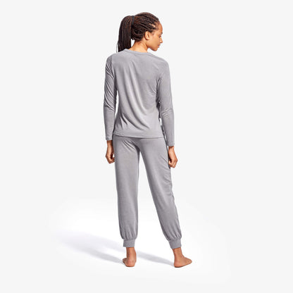 Woman wearing gray pajama set on a white background