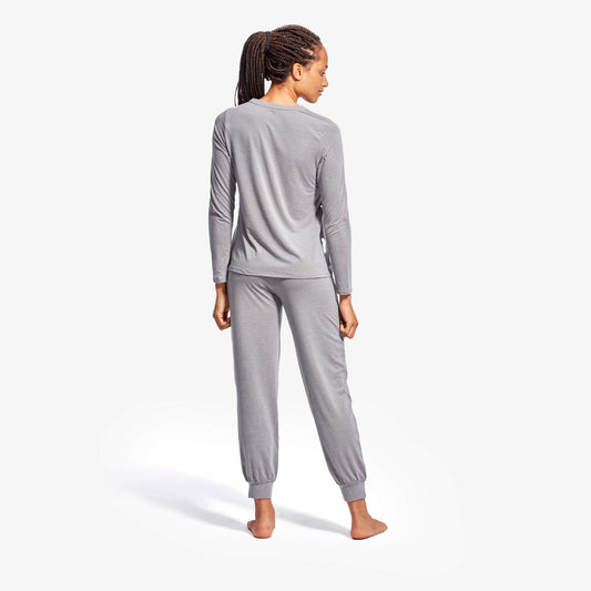 Woman wearing gray pajama set on a white background