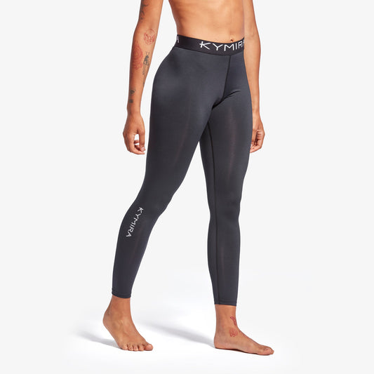 Person wearing black leggings with Kymira branding on a white background