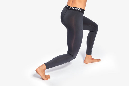 Person wearing black leggings with 'MIRA' branding on a white background