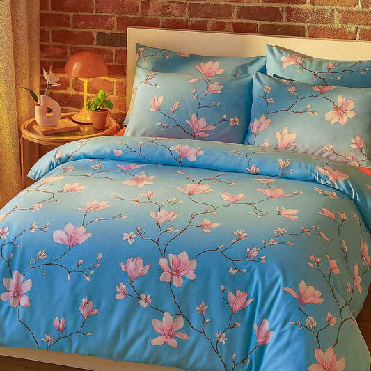 Floral bedding set with pink flowers on a blue background in a bedroom setting.