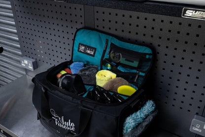 Black and teal tackle bag with fishing gear on a pegboard wall