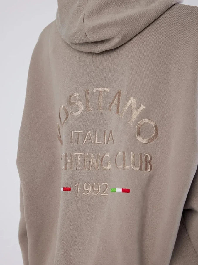 Beige hoodie with embroidered text and flag design on a white background