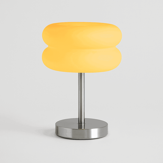 Yellow table lamp with a metallic base on a light gray background
