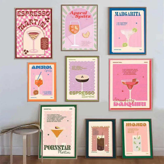 Collection of framed cocktail posters on a wall with a stool in the foreground.