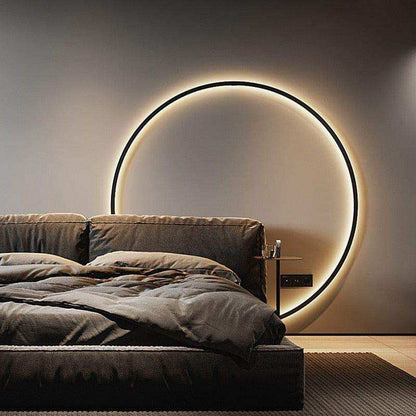 Modern bedroom with a circular light fixture on the wall above a bed.