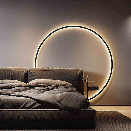 Modern bedroom with a circular light fixture on the wall above a bed.