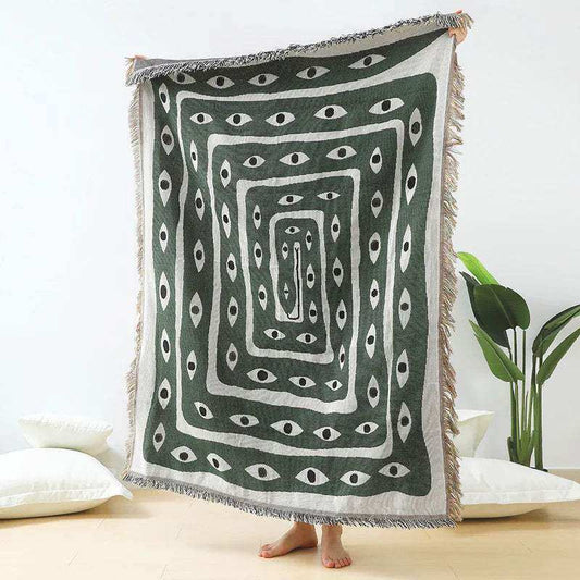 Decorative throw blanket with eye pattern on a white background