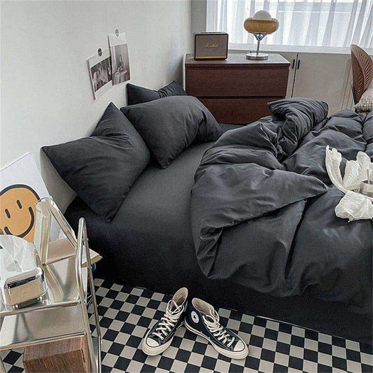 Bedroom with dark gray bedding, checkered floor, and wooden nightstand.