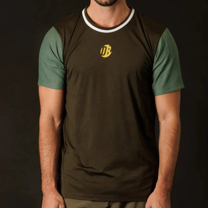 Person wearing a brown and green t-shirt with a logo on a black background