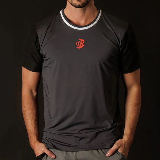 Person wearing a black t-shirt with a red logo on a dark background