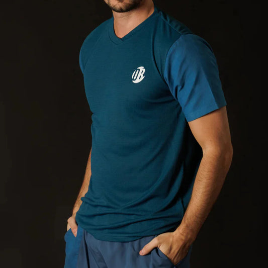 Person wearing a blue t-shirt with a logo on a black background
