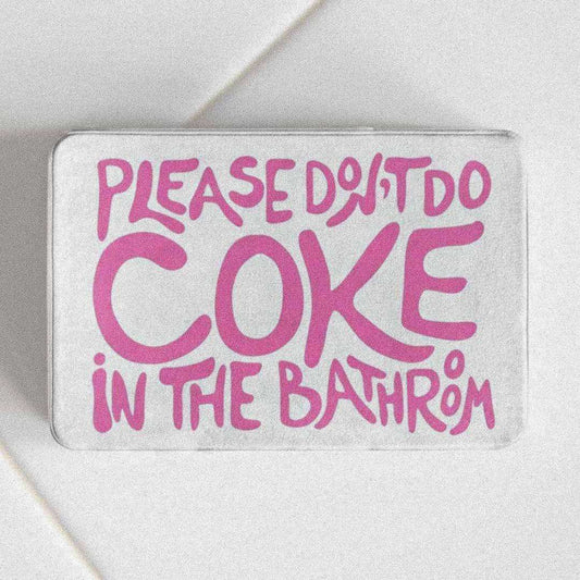 Gray bath mat with pink text 'Please do not do coke in the bathroom' on a white background