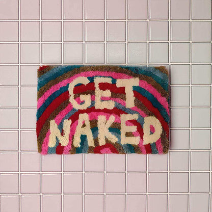 Colorful doormat with 'GET NAKED' text on a tiled floor