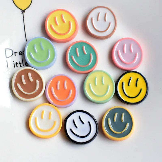 Colorful smiley face fridge magnets on a white background