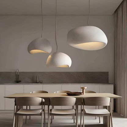 Modern dining area with pendant lights and a kitchen in the background