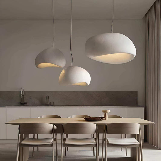 Modern dining area with pendant lights and a kitchen in the background