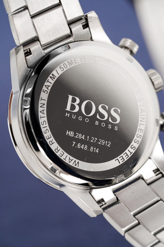 Close-up of a silver Hugo Boss watch with brand name on a dark background