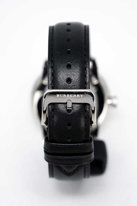 Black Burberry watch with leather strap on a white background